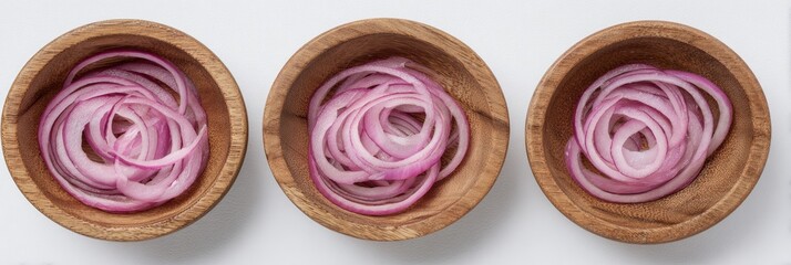 Three small wooden bowls filled with thinly sliced red onions arranged in a neat spiral pattern, set against a white background