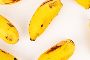 Multiple yellow bananas fill the frame creating full, tight pattern with white space separation.