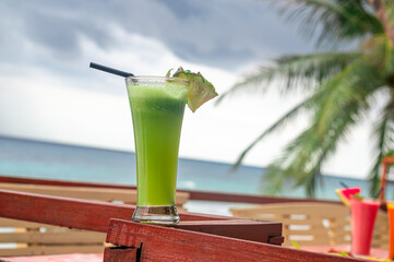 Refreshing Green Juice Cocktail Served Outdoors with a Tropical Ocean View