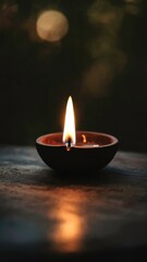 Golden diya glowing in darkness, symbolizing tradition and festive spirit in Indian culture.
