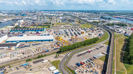 Fototapeta premium Drone view Rotterdam city with river on cloudy horizon. Industrial area of ​​Rotterdam, Netherlands