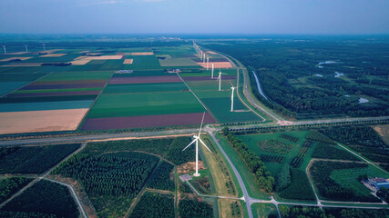 Drone view of rural evening landscape with wind farm. Netherlands. Alternative energy, green energy.