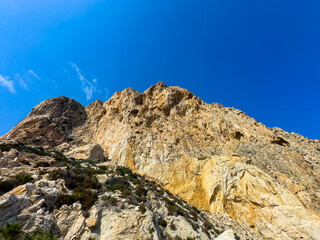 Majestic rocky mountain rising against a clear blue sky showcases nature's beauty in a serene wilderness setting