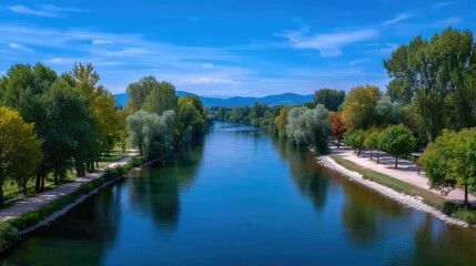 Scenic River Flowing Through Lush Green Trees Under a Bright Blue Sky Calm Waters Reflecting Sunlight Natural Beauty and Tranquil Scenery in Daylight