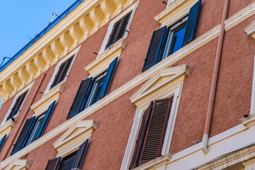 Obraz premium Window shutters. Wall house facade. Residential buildings. Old architecture in the city center Italy, Rome. Italian street