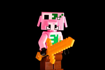Naklejka premium LEGO Minecraft Zombie Piglin with a golden sword on a black background