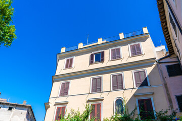Window shutters. Wall house facade. Residential building. Old architecture in city center Italy, Rome. Italian street. Blue summer sky on street