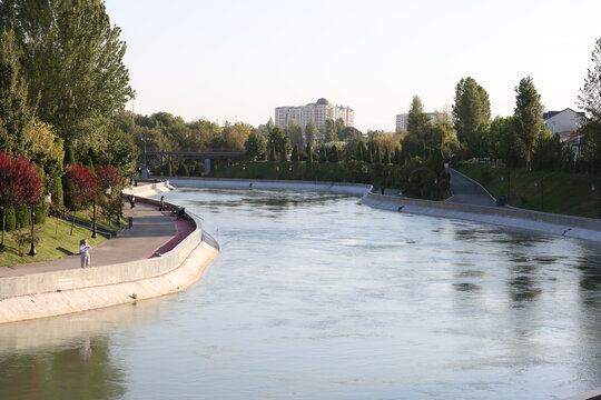 River flowing through a city park on a sunny day