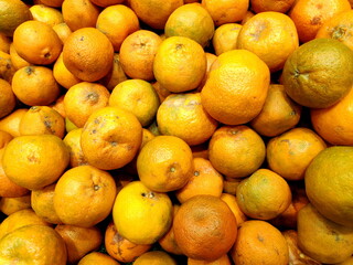 Pile of tangerines sits on display at local market, showcasing vibrant colors and fresh produce, creating an inviting and healthy shopping experience.