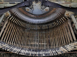 Vintage typewriter keys show signs of age in closeup shot, revealing intricate mechanism and worn...