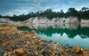 Abandoned quarry pond with rocky ground and turquoise water.