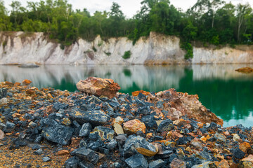 Abandoned quarry pond with rocky ground and turquoise water.