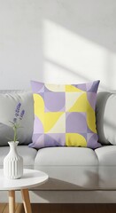 Modern living room interior with a grey sofa, white side table, and a geometric pattern throw pillow in purple and yellow.