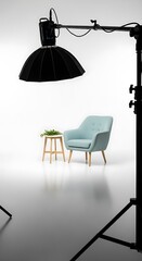 Studio setup with a light, chair, table, and plants against a white backdrop.