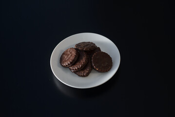 Biscuits covered with chocolate on both sides on a white plate
