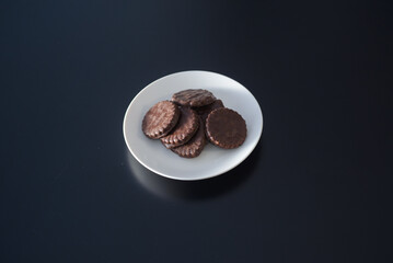 Biscuits covered with chocolate on both sides on a white plate