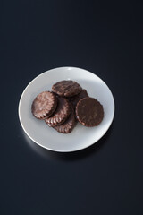 Biscuits covered with chocolate on both sides on a white plate