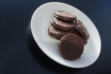Biscuits covered with chocolate on both sides on a white plate