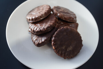 Biscuits covered with chocolate on both sides on a white plate