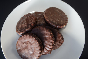 Biscuits covered with chocolate on both sides on a white plate