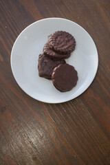 Biscuits covered with chocolate on both sides on a white plate