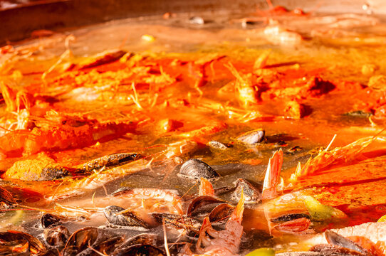 Fish, shrimp  and mussel, cooking in tomato sauce, seafood stew, simmering at fish monger kitchen, at a farmers market in Sablet, France