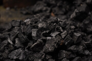 A person handling black coal pieces, showing hard manual work and energy source mining concept, symbolizing industrial power and fuel