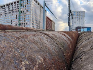 Close-up image of stacked industrial pipes showing signs of rust and structural wear in heavy-duty construction environment.