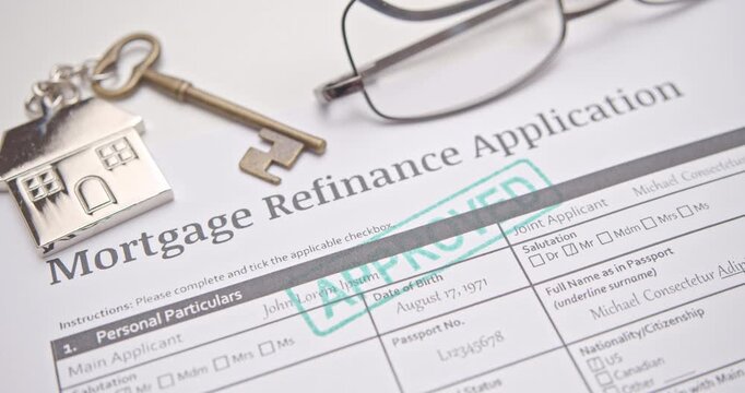 A video footage showing a close-up of a hand using a green rubber stamp with the word "APPROVED" on a Mortgage Refinance Application form. The application has been successfully accepted and authorized