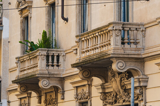 Stone balconies with classic columns on historic Milan building facade