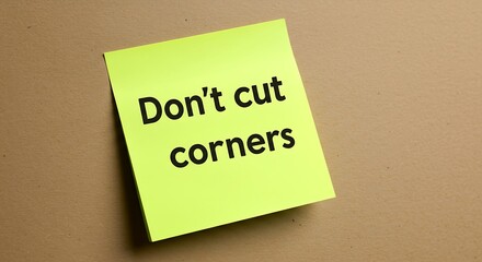 Motivational message on yellow sticky note against a neutral background