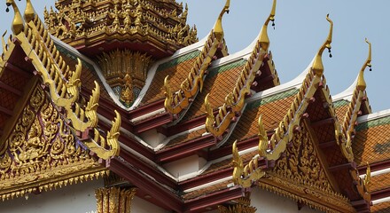 Ornate golden roof of a traditional architectural structure against a bright sky