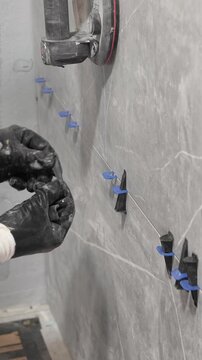 The master tiler inserts the blades into the tile leveling system and tightens it with a special tool