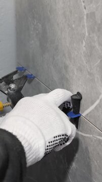 The master tiler inserts the blades into the tile leveling system and tightens it with a special tool
