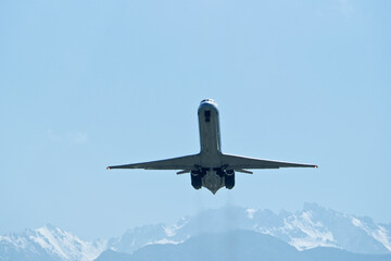 The plane climbs after takeoff. Airplane in flight against the backdrop of snow-capped mountains