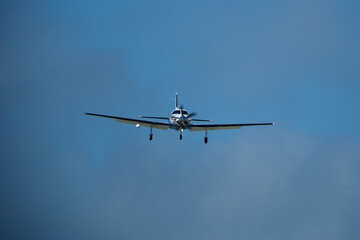 Small propeller airplane flying in the blue sky on a sunny day. Single Engine Turboprop Aircraft Landing
