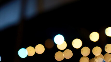 Blurred city lights shine brightly at night, creating a bokeh effect with warm and cool tones, evoking a sense of urban energy and mystery. © onyengradar