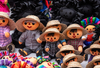 A collection of dolls with straw hats and colorful clothing. The dolls are arranged in a row. Historic center of Queretaro City, decorations and traditions to celebrate Mexico's Independence Day, colo
