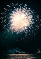 Vietnam, Nha Trang -07 June 2025:A luxurious fireworks display is launched from a ship along Nha Trang's coast, with lights illuminating water, creating a celebration scene for beach spectators.