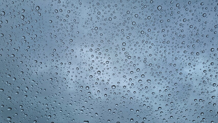 A sad landscape behind raindrops. Raindrops on glass close-up. Selective focus