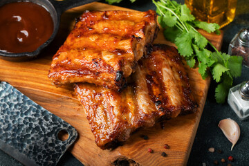 Spicy hot grilled spare ribs from a summer BBQ served with a hot chili pepper and fresh tomatoes