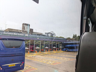 Obraz premium Atmospheric view from a bus window of coaches at Glasgow's Buchanan Bus Station on a rainy day.