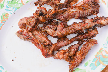 close-up overhead shot of several pieces of cooked, grilled, or fried meat served on a plate