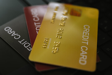 Close-up of credit cards stacked on a laptop keyboard, symbolizing online shopping, banking, and financial transactions.