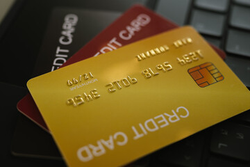 Close-up of credit cards stacked on a laptop keyboard, symbolizing online shopping, banking, and financial transactions.