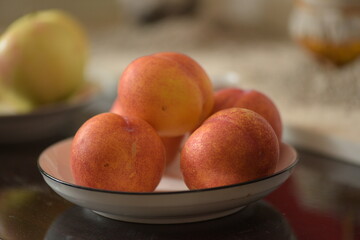 Fresh peaches placed on a plate, still life close-up