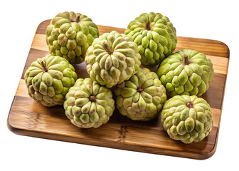 Fototapeta premium A wooden cutting board displays a cluster of ripe green custard apples isolated on transparent background