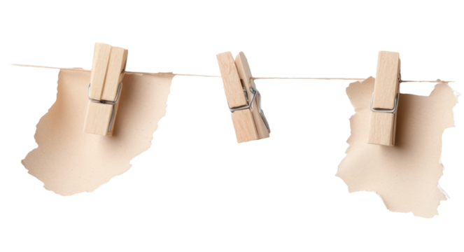 Torn paper sheets hanging on clothesline with wooden pegs