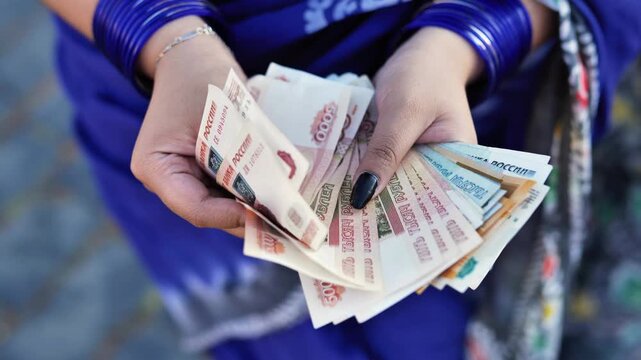 Indian woman's hands counting Russian ruble banknotes