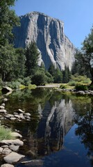 Majestic granite peak mirrored perfectly in a tranquil river, showcasing the serene beauty of nature's reflection.
